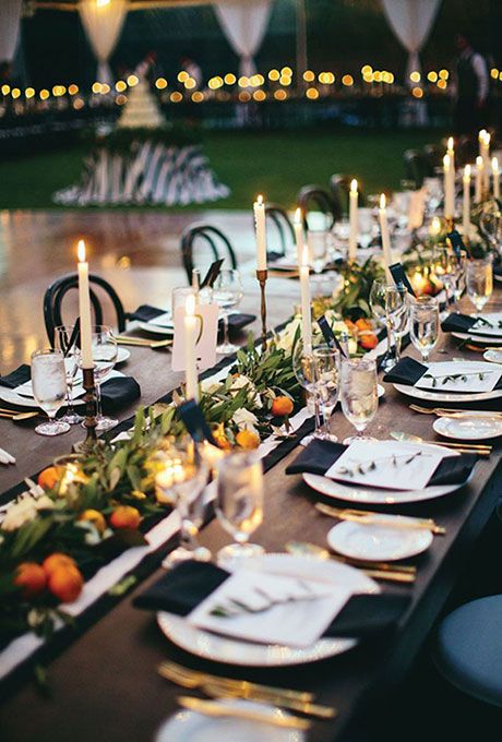 Brides.com: . A greenery and orange garland stands out against this elegant black-and-white reception table. White Reception Table, Ojai Valley Inn And Spa, White Table Settings, Gold Motif, Modern Table Setting, Evening Reception, Citrus Wedding, Yellow Table, Reception Centerpieces