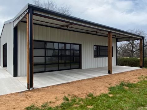 Metal Gym Building, Metal Shop With Patio, Shop With Patio, Metal Building With Glass Garage Doors, Metal Building Rec Room, Metal Building Workshop Ideas, Metal Building Salon, Metal Building With Lean To, White Metal Shop With Black Trim