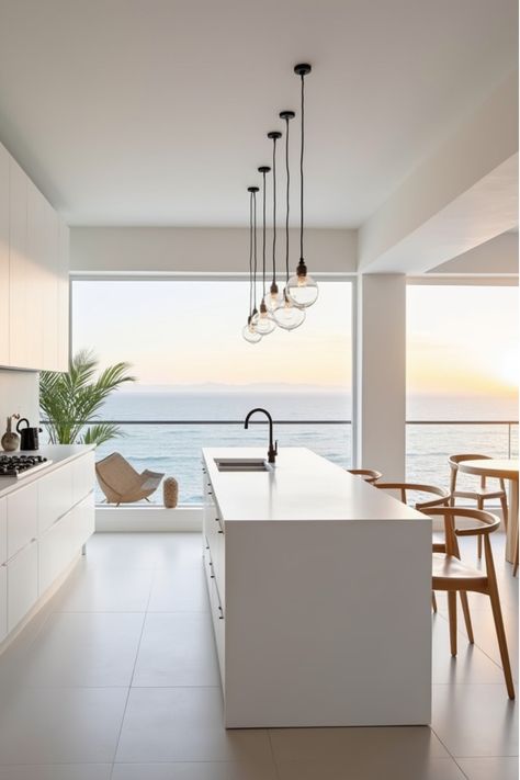 Minimalist white coastal kitchen with glass globe pendant lights and sunset view Modern Coastal Light Fixtures, Beach Shack Kitchen, Coastal Renovation, Scandinavian Beach House, Coastal Kitchen Lighting, Bali Kitchen, White Coastal Kitchen, Minimalist Beach House, Coastal Light Fixtures