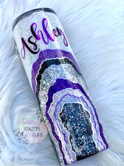 This listing is for a super gorgeous and sparkly realistic geode glitter tumbler. Various shades and sizes of purple, silver, and black are hand painted on the cup to resemble a geode rock with accents in complimentary colors. The geode is defined by shiny silver and purple lines and filled in with a super sparkly white opal glitter. A name can also be added if requested! If you would like a name on the cup - please add it to the personalization box and indicate your font choice from the listing Geode Tumbler, Purple Geode, Geode Rocks, Gold Tumbler, Black Tumbler, Glitter Tumbler Cups, Purple Line, Glitter Tumblers, Tumbler Cups Diy