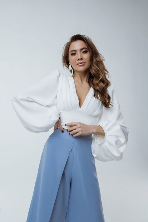 This puff-sleeve V-neck blouse is the epitome of elegance. The puffed sleeves create a flattering silhouette, while the backless design adds a touch of sexiness. Dress it up with high-waisted culottes from our collection. #puffsleeveblouse #vneckblouse #backlessblouse #femininefashion #sophisticatedstyle #elegantblouse #statementtop High Waisted Culottes, Kibbe Romantic, Puff Sleeves Top, Backless Blouse, Wear Store, Satin Long Sleeve, Elegant Blouses, Backless Design, Silk Slip Dress