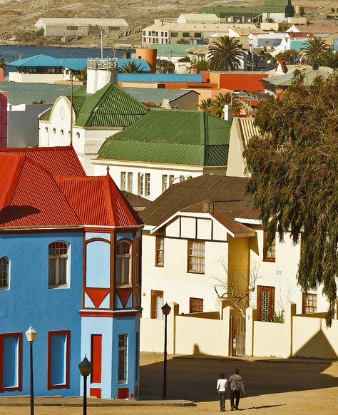 A colorful street in in Lüderitz, which is on the southern Namibian coast. Namibia used to be the German colony of SW Africa prior to WWI, thus many of its towns have German names. One of the few places in Africa where the German language is commonly spoken. Namibia Aesthetic, West African Architecture, African Cities Aesthetic, Namibia Architecture, Nama People Namibia, German Names, Namibia Travel, Schwabisch Hall Germany, Building Aesthetic