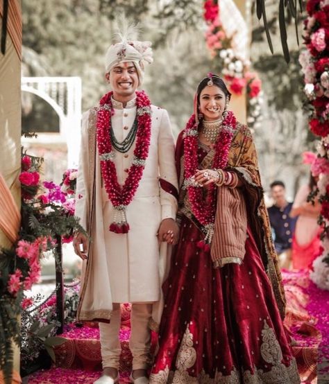 Indian Wedding Couples Outfits, Indian Couple Wedding Outfit Bridal Lehenga, Sherwani With Red Lehenga, Varmala Designs For Red Lehenga, Varmala For Red Lehenga, Phera Outfit Bride, Red Jaimala, Bride And Groom Indian Wedding Outfit Red, Red Garland Indian Wedding