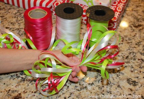 How To Wrap Gifts Like a Pro Without Busting Your Gift Budget - Curling Ribbon Ideas Gift Wrapping Christmas, Gift Basket Tutorial How To Make, Diy Curly Ribbon Bows For Gifts, Easy Gift Bows With Ribbon, Gift Bag Ribbon Ideas, Curly Ribbon Bows For Presents, Easy Ribbon Bows Diy Gift Wrapping, How To Wrap Presents With Ribbon, How To Use Ribbon On Gifts