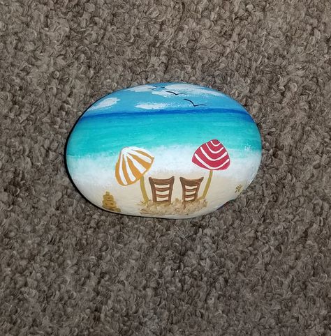 I free hand painted this summer beach scene rock. Painted Rock Beach Scene, Beach Theme Rock Painting, Rock Painting Ideas Beach Theme, Hand Painted Rocks Ideas Beach Stones, Beachy Painted Rocks, Beach Theme Painted Rocks, Beach Painted Rocks Ideas, Beach Rock Painting Ideas, Rock Painting Ideas Beach