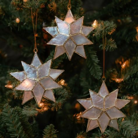 * Set of three capiz shell ornaments * Three dimensional star shape * Measures approx. 4" height * Translucent pearl color * Gold wire details * A hanging loop attached * Traditional capiz shell craft * Made in Philippines ------------------------- Capiz shell crafts are a popular craft in Philippines. Our capiz products are made by artisans working in small producer groups. Capiz is the shell of windowpane oyster. These shells are flat, translucent and have appearence like pearl. These shells w Capiz Shell Crafts, Glowing Star, Pearl Ornaments, Shell Craft, Wine Bottle Topper, Small Storage Basket, Popular Crafts, Bottle Toppers, Shell Ornaments