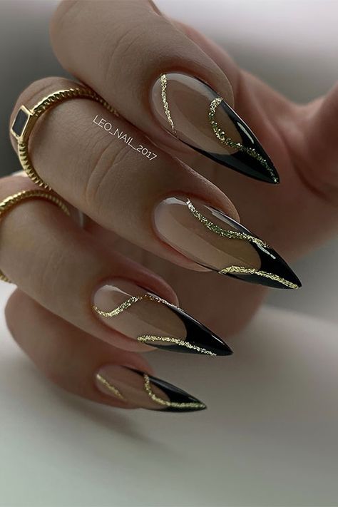 Classy stiletto black French tip nails with gold glitter swirl nail art Nails To Go With Black Outfit, Black Gold Tip Nails, Gold Nails Black Tips, Black And Gold Tips Nails, Gorgeous Almond Nails, French Black Nail Designs, Gold Black French Nails, Gel Tips Nails Ideas Art Designs, Wedding Nails Black And Gold