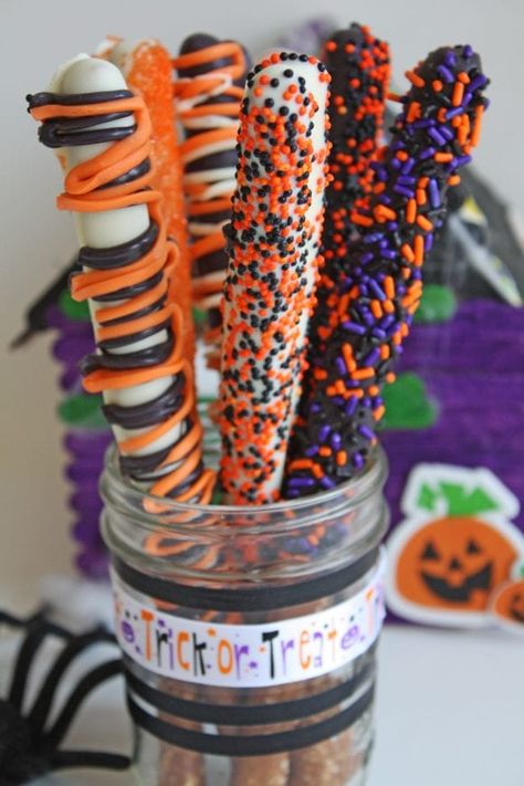 Make These Quick and Easy Halloween Pretzel Rods! | Catch My Party Halloween Pretzel Sticks Dipped, Chocolate Covered Pretzel Rods Halloween, Chocolate Dipped Pretzel Rods Halloween, Halloween Dipped Pretzel Rods, Pretzel Rods Halloween, Candyland Treats, Halloween Pretzel Rods, Gourmet Pretzels, Halloween Treats Ideas