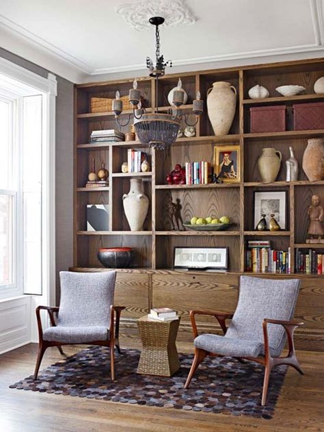 Wood finishes are warm and inviting – highlight the unique beauty of the wood by purposefully leaving empty space around collectibles so that the grain is visible, and choose objects in lighter colors and sculptural shapes that stand out against the stain. Mid Century Bookcase, Book Cases, Library Ladder, Basement Playroom, Decorating Bookshelves, Bookshelves In Living Room, Wood Bookshelves, Home Library Design, Built In Bookcase