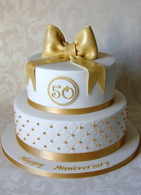 Ivory two tier stacked 50th golden wedding anniversary celebration cake with gold sugar 50s and hearts trimmed with gold chiffon ribbon. Description from pinterest.com. I searched for this on bing.com/images Golden Anniversary Cake, Golden Wedding Cake, Golden Wedding Anniversary Cake, 50th Wedding Anniversary Cakes, 50th Anniversary Cakes, 50th Wedding Anniversary Party, Wedding Anniversary Cakes, 50th Anniversary Party, Wedding Anniversary Cake