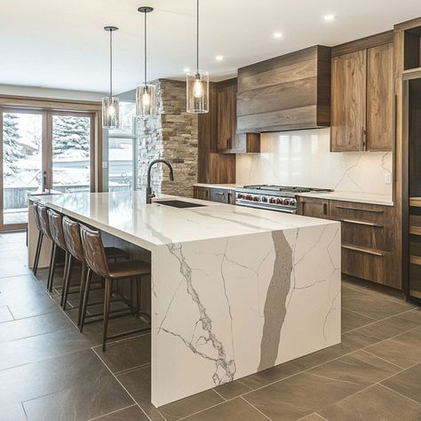 This stunning modern kitchen features a quartz waterfall island, highlighting the elegance and durability of quartz as a premium building material. With natural wood cabinetry and stone accent walls, the design blends warm wood tones with sleek, contemporary finishes. The quartz island serves as a focal point, perfect for social gatherings or culinary prep. Pendant lighting, open seating, and floor-to-ceiling windows complete this inviting space. Quartz Waterfall Island, Loft Kitchen Ideas, Building Materials Architecture, Quartz Island, Waterfall Island Kitchen, Kitchen With Quartz, Waterfall Island, Stone Accent Walls, Loft Kitchen