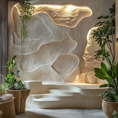 Transform interiors with sculptural plaster walls inspired by nature. This wave-like plaster design, enhanced with built-in planters and soft lighting, creates a serene and organic aesthetic, perfect for modern spaces. Ideal for biophilic design lovers, plaster’s versatility as a building material allows for creating immersive and calming environments that connect with nature.