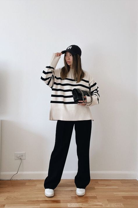 New york city based fashion influencer Lauren Lora wearing a casual cold weather outfit. She’s wearing a black and white oversized striped sweater, black wide leg trousers, white sneakers, a yankees hat and a black chanel classic flap. How To Style A Vest, Striped Sweater Outfit, Black Sweater Outfit, Oversized Sweater Outfit, Cold Weather Outfit, Classic Style Outfits, Pull Oversize, Winter Fashion Outfits Casual, Chiffon Floral