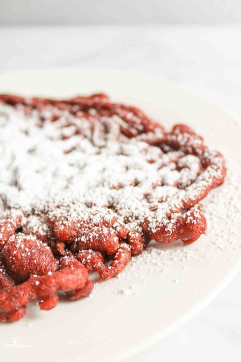 red velvet funnel cakes are a fun twist on a classic treat. Stay home and avoid fair crowds with this easy funnel cake recipe. Using pancake mix as the base, every bite is tangy, sweet, chocolatey and so delicious. Especially when served with a dusting of powdered sugar on top. Red Velvet Funnel Cake Recipe, Red Velvet Funnel Cake, Funnel Cake Batter, Funnel Cake Fries, Cake Batter Recipes, Churro Bites, Easy Red Velvet, Recipes Using Cake Mix, Buttermilk Pancake Mix