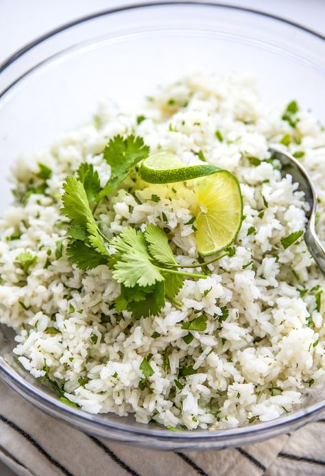 Bright and zesty, this easy cilantro lime rice is a fluffy rice side with an unexpected burst of flavor. Topped with extra cilantro for a pop of color, it's a simple 30-minute recipe that'll add extra personality to your meals. Easy Cilantro Lime Rice, Cilantro Rice Recipe, Cilantro Lime Rice Recipe, Lime Rice Recipes, Cilantro Rice, Fluffy Rice, Chicken Tacos Crockpot, Rice Side, Rice Side Dishes