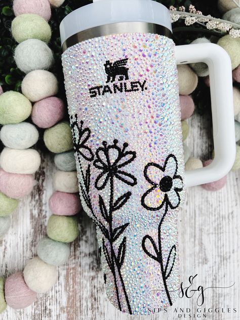 This listing is for a ready to ship 40oz with handle floral  Rhinestone tumbler. The tumbler itself is stainless steel double wall vacuum insulated to insure your drinks stay hot/cold for hours. Stones are high quality glass rhinestone. All stones are hand placed one by one with a high quality nontoxic adhesive. Hand wash only. Since all stones are glass they can break if dropped. Handle with care. Losing a stone is unlikely, but possible. I will include a small bag with replacement stone. We do not accept returns on drinkwear but if there is an issue with your order please don't hesitate to send us a message  **Care instructions** -hand wash only -Not microwave safe -Do not soak - Sensitive to extreme temperatures, do not put in freezer or leave it in the car for long periods of time. Handle Tumbler Ideas, Black Rhinestone Tumbler, Fall Rhinestone Tumbler, Bling Cups Rhinestones Diy, Rhinestone Cups Tumblers, Things To Rhinestone, Rhinestone Tumbler Ideas, Epoxy Business, Blinged Cups