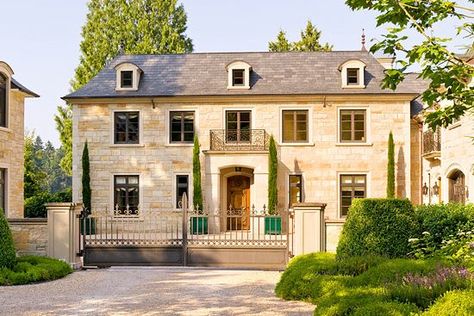 Although built in the 21st century, this home looks as authentic as the 18th-century European manor house it was modeled after. Built in the courtyard vernacular, the home, like many others in the French countryside, contains a large square gravel forecourt. Its warm, honey-hue limestone ranges from white to caramel in color; a mixture of smooth and rough-cut pieces were used to create a traditional look. Rustic details, such as a simple portico and wrought-iron flourishes, add impeccable old-wo Large Homes Exterior, French Country House Exterior, French Country Chateau, French Country Houses, Country Home Exterior, French Country Exterior, Beautiful Exterior, French Apartment, European Elegance