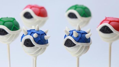 Learn how easy it is to make these yummy Mario Kart 8 Koopa Shell Cake pops using chocolate cake and frosting. Yield: makes 12 cake pops   Things you'll need Ingredients 1 chocolate cake mix 1 chocolate frosting Candy melts: white, blue, red, green Decorating icing: white, blue, red, green, black White fondant Equipm Mario Cake Pops, Koopa Shell, Cake Pop Receita, Mario Kart Cake, Shell Cake, Blue Cake Pops, Nerdy Nummies, Mario E Luigi, Mario Cake