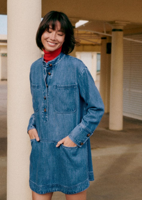 The Sézane Salomé Dress in Deep Blue combines casual sophistication with effortless style. This oversized short dress features long sleeves, a high collar, and a button placket closure. The design includes practical patch pockets at the bust and inlaid waist cut-outs, offering both form and function. Ideal for layering over tights or pairing with your favorite boots. Check out our latest arrivals at sezane.com or via the app. Lifestyle Dresses, Eliza Dress, Denim T Shirt, Favorite Boots, Swimwear Dress, Victoria Dress, Knitwear Dress, Collar Dress, Swimwear Accessories