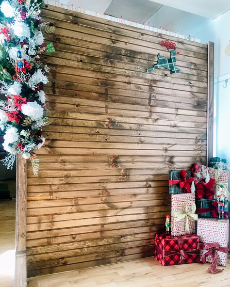 Wooden backdrop decorated with holiday decor Indoor Christmas Backdrop Ideas, Christmas Wood Backdrop Ideas, Pictures With Santa Backdrop Diy, Santa Background Photo Backdrops, Holiday Selfie Station, Santa Backdrops For Pictures Diy, Holiday Party Photo Backdrop, Holiday Photo Backdrop Ideas, Pictures With Santa Backdrop