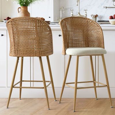 This set of coastal-style bar stools adds a relaxed, textured charm to your kitchen or dining area. Each stool features an oversized full back and a natural rattan backrest, combining breathability and style. The sleek metal legs, with a wood-look finish, add a modern touch to your space. The gently curved backrest and foam-padded seat, upholstered in cozy beige boucle fabric, ensure comfort for you and your guests. Complete with a convenient footrest and metal glides to protect your floors, the Wicker Barstools In Kitchen, Boho Bar Stools, Boho Bar, Rattan Counter Stools, Boucle Fabric, Kitchen Bar Stools, Beachcrest Home, Game Room Furniture, Coastal Style