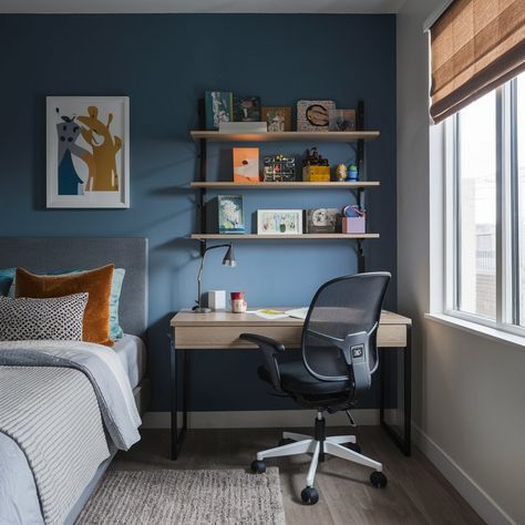 A stylish and functional teenage bedroom design. The room features a sleek, modern desk with a comfortable ergonomic chair. The desk has ample space for a laptop, notebooks, and various stationery. The wall is adorned with colorful artwork, creating a vibrant and motivating atmosphere. Teen Bedroom With Desk Boy, Young Boys Desk In Bedroom, Teen Boy Desk, Boys Bedroom With Desk, Pre Teen Boys Desk, Boys Desk In Bedroom, Teenager Bedroom Boy Modern, Teenager Bedroom Boy Wall Shelves, Tennage Boy Room Design