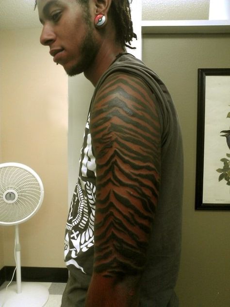 very interesting tiger skin tattoo. I think it would look much better on lighter skin; he should have done it on his inner arm to show some orange. Tiger Print Tattoo, Tiger Pattern Tattoo, Tiger Skin Tattoo, Tiger Stripes Tattoo, Tiger Stripe Tattoo Arm, Tiger Stripe Tattoo, Tiger Inner Bicep Tattoo, White Tiger Forearm Tattoo, Forearm Tiger Eyes Tattoo