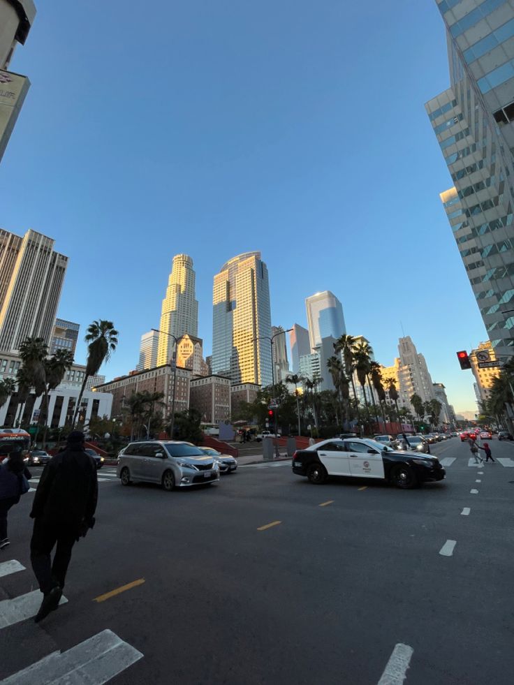 a city street filled with lots of traffic and tall buildings in the backround