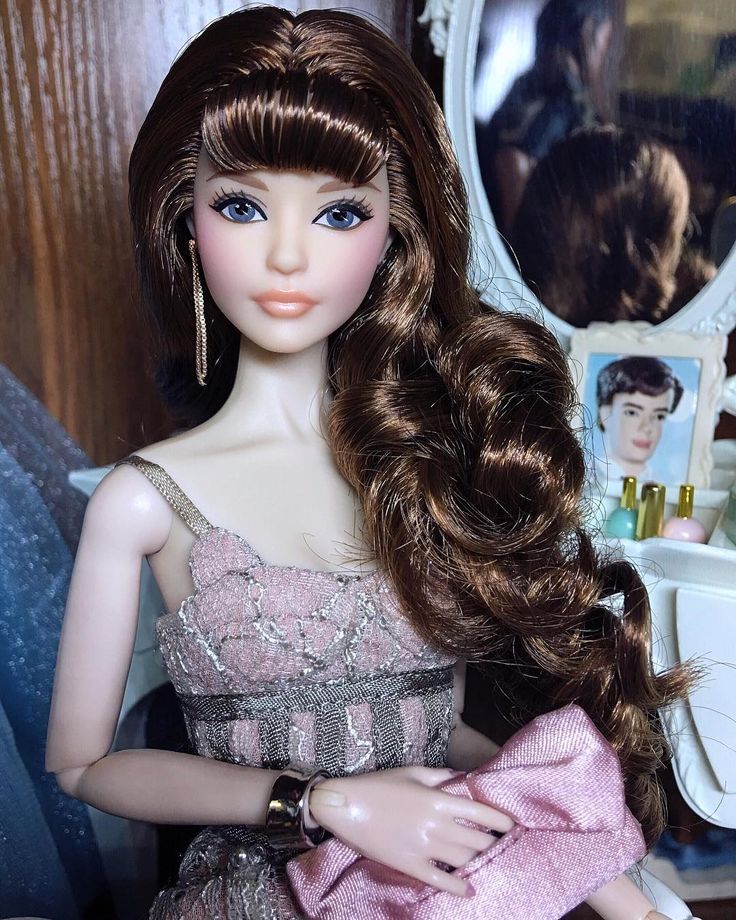 a close up of a barbie doll with long hair and wearing a pink evening dress