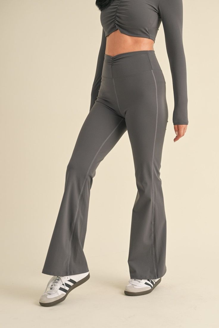 Expertly designed for a comfortable and stylish fit, our Ruched Waist Flare Leggings feature a flattering ruched waistband and soft, stretchy fabric. Perfect for any workout or everyday wear, these leggings provide both fashion and function. Gray Stretch Elastane Bottoms, Casual Gray Elastane Leggings, Casual Tight Leggings With Contoured Waistband, Casual Leggings With Contoured Waistband, Stretch High-waisted Elastane Sweatpants, Versatile Tight Activewear With Elastic Waistband, Gray Yoga Pants For Fall, Fitted Leggings With Elastic Waistband For Pilates, Full Length Tight Activewear With Elastic Waistband