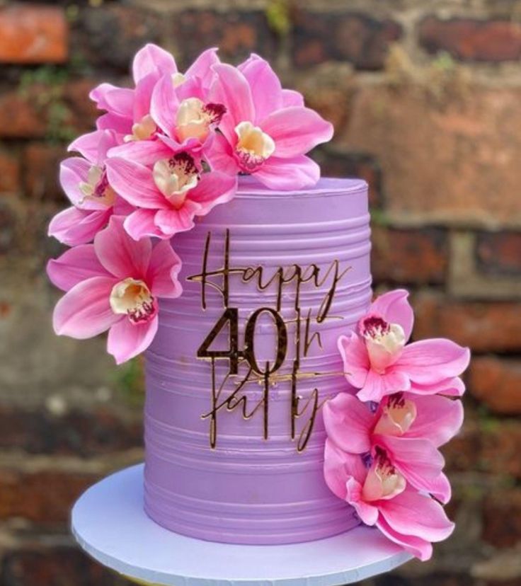 a purple cake with pink flowers on top and happy forty birthday written on the side