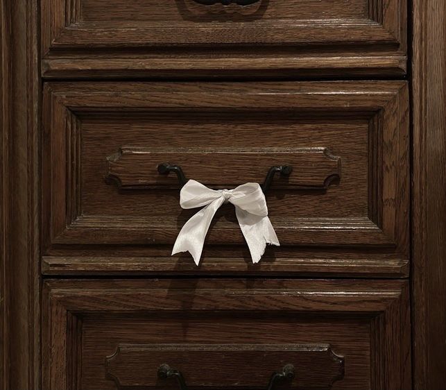 a drawer with a white bow on it