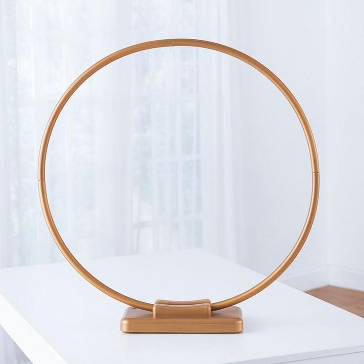 a round wooden object sitting on top of a white table in front of a window