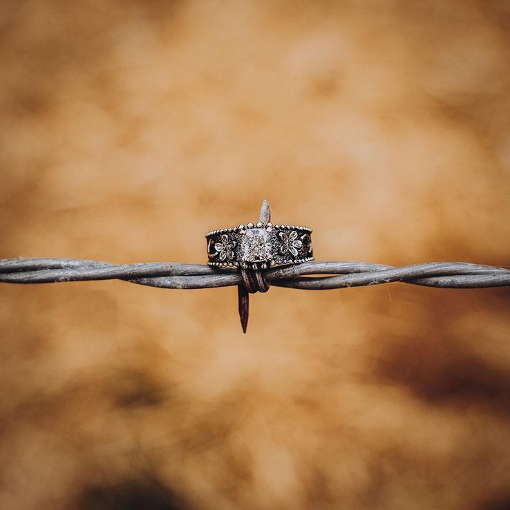 two wedding rings sitting on top of a barbed wire