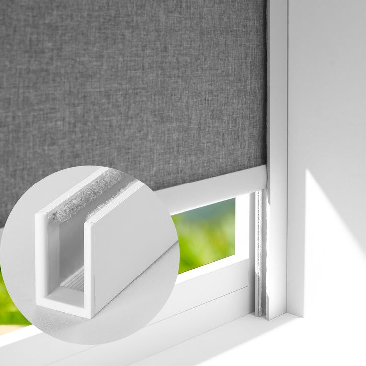 an open window with the blinds pulled back to reveal a green background and white trim