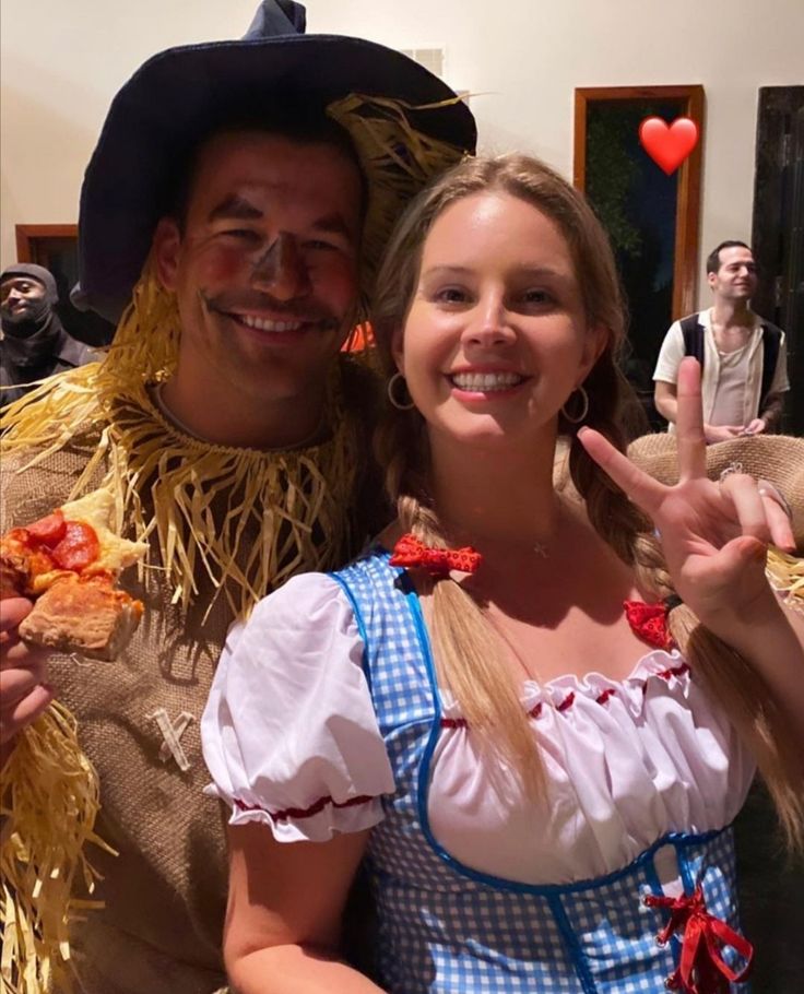 a man and woman dressed in costumes posing for the camera