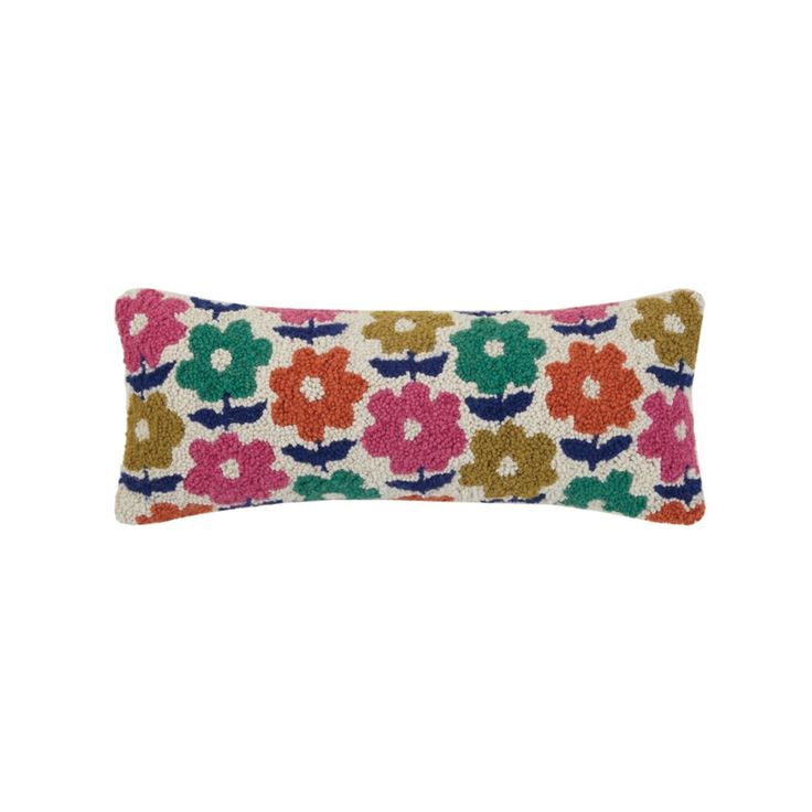 an embroidered pillow with colorful flowers on the front and back, sitting on a white surface