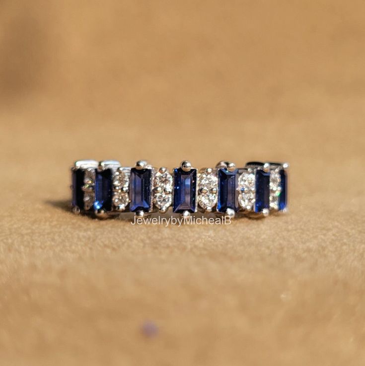 three blue and white diamond rings on a brown surface