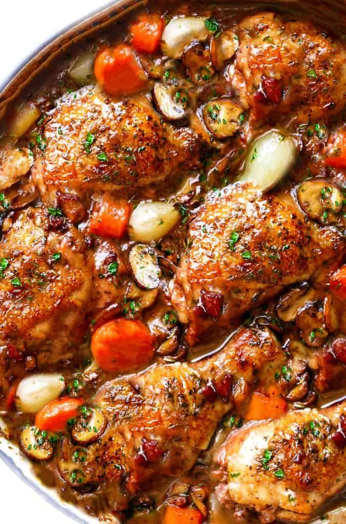 chicken thighs with carrots and onions in a pan