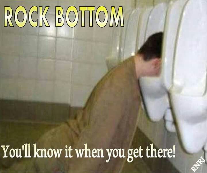 there is a man that is leaning over the toilet in the bathroom and it says, rock bottom you'll know it when you get there