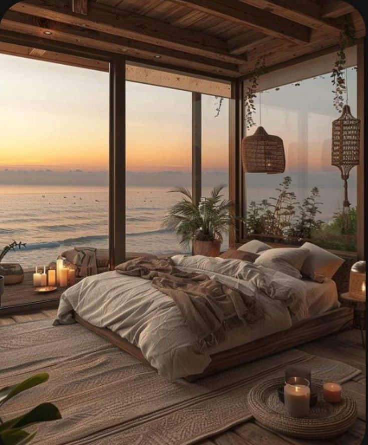 a bedroom with an ocean view and candles on the bed in front of large windows