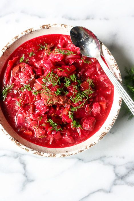 a white bowl filled with red sauce and garnished with parsley