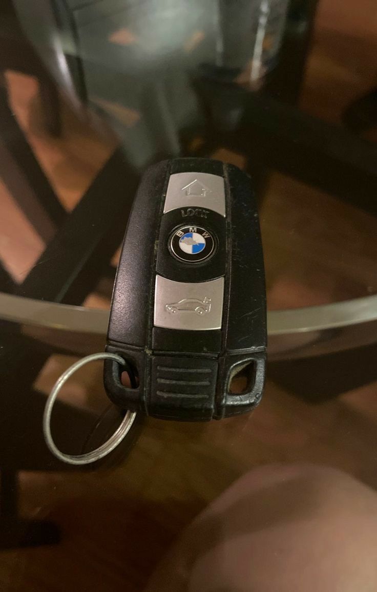 a bmw key chain attached to a glass table