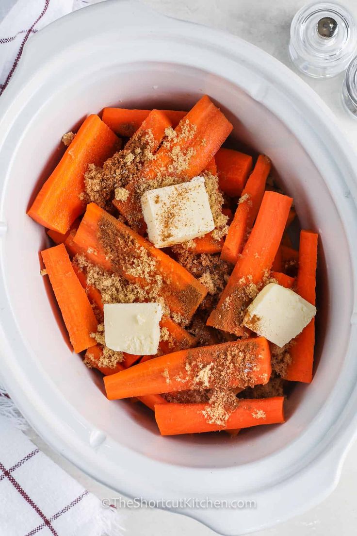 carrots with parmesan cheese and seasoning in a white bowl on a table