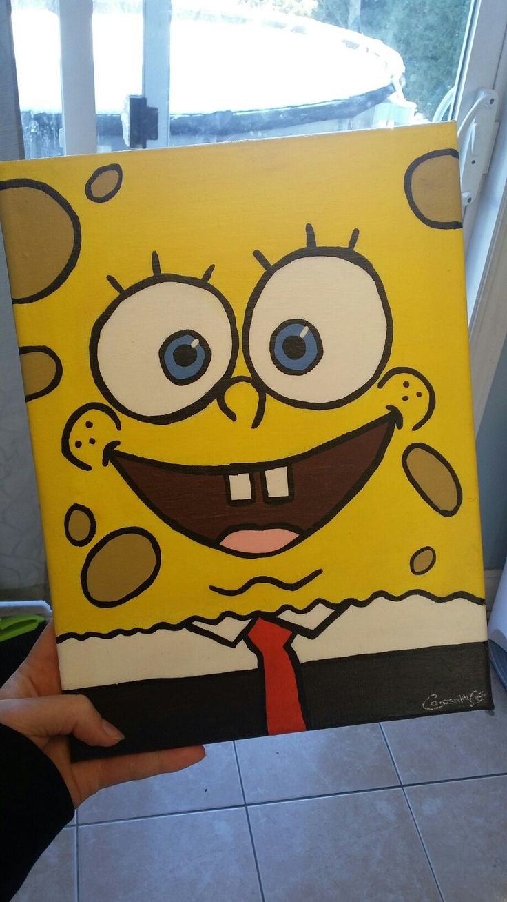 someone holding up a painting of spongebob