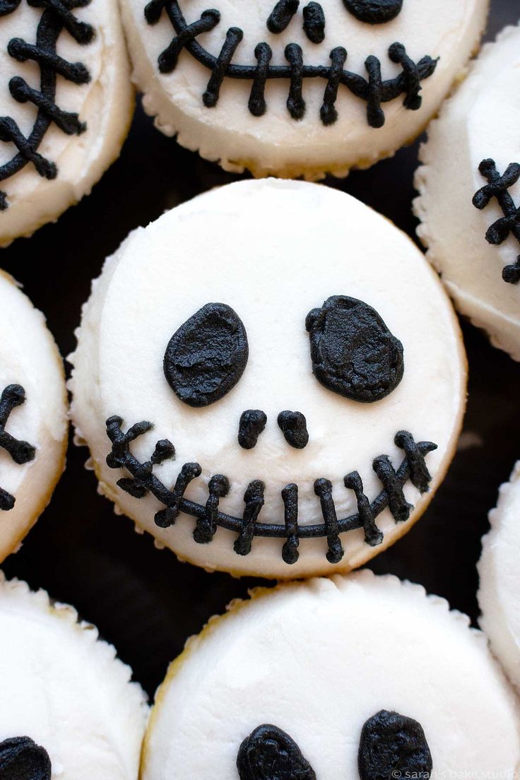 decorated cookies with black icing and white frosting are arranged in the shape of a skull