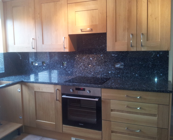 a kitchen with wooden cabinets and black granite counter tops on the counters is pictured in this image