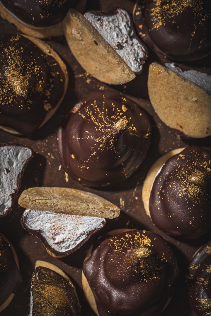 chocolate covered donuts with gold sprinkles and powdered sugar on them