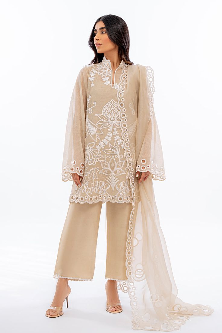 An ethereal sand coloured khaddi corduroy shirt is rendered with bold ivory dori embroidery. Eyelet details on scalloped edges are featured on the shirt as well as on the matching organza dupatta. Complete the look with our signature rawsilk culottes accented with embroidered details. Organza Punjabi Suits, Culottes Outfit Indian, Cream Organza Sets With Lace Work, Elegant Embroidered Organza Palazzo Set, Cream Organza Sets With Intricate Embroidery, Elegant Cream Organza Set, Elegant Cotton Silk Palazzo Set With Chikankari Embroidery, Elegant Beige Sharara With Sheer Dupatta, Off White Organza Sharara With Resham Embroidery