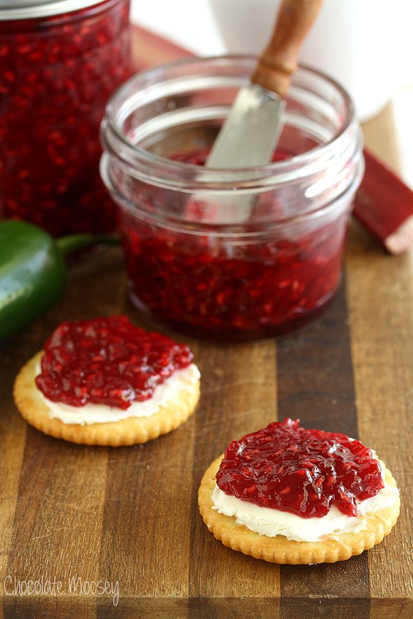 two crackers with jam on them sitting on a cutting board